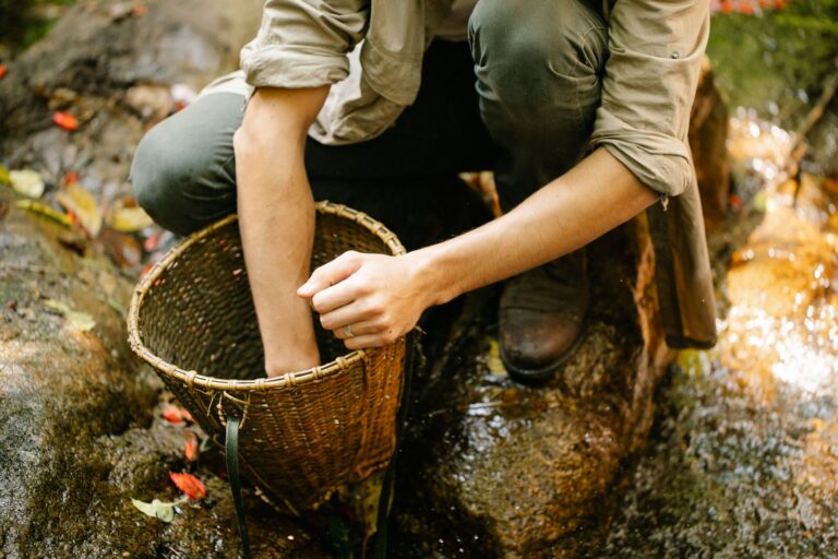 Wanderer entnimmt Wasser an einem Bach für die Aufbereitung
